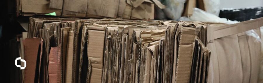 Stacks of recycled cardboard boxes in a warehouse, symbolizing sustainable practices and sustainability in business operations.