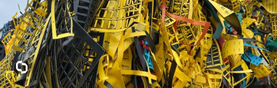 A heap of colorful shredded plastic scraps, including yellow, black, and blue pieces, highlights the waste generated by single-use plastic items. This image supports the blog topic what is plastic by illustrating the environmental issue of plastic's non-biodegradability and emphasizing the importance of reusing plastic materials to reduce waste.