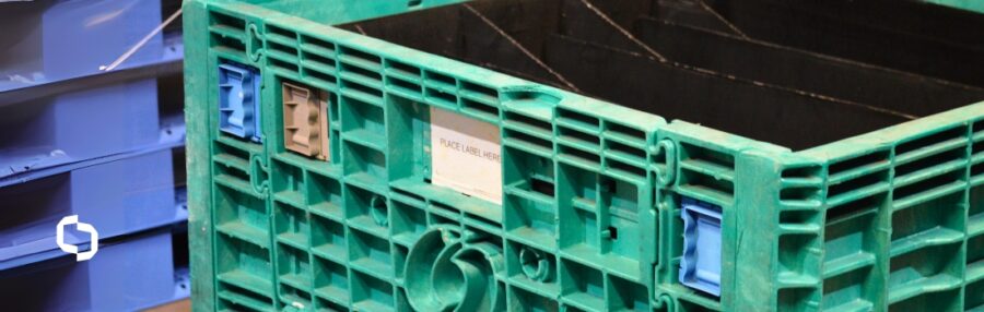 Green reusable container with modular sections in a warehouse, showing Extera’s expertise in container modifications and custom containers designed for durability and efficiency.