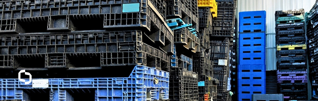 Stacks of plastic shipping containers in various colors awaiting inspection as part of Extera’s industrial container repair process.