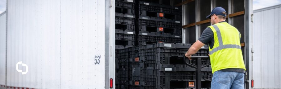 Worker loading stacked reusable plastic bulk containers into a 53-foot trailer, demonstrating how nesting and stacking impact truckload capacity and overall trailer capacity efficiency.