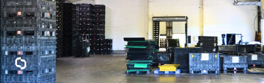 Warehouse stacked with leased plastic containers and pallets, illustrating assets covered under a container leasing agreement