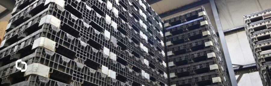 Stacked reusable plastic pallets in a warehouse, illustrating how tracking ESG requirements and criteria supports durable, low-waste supply chains.