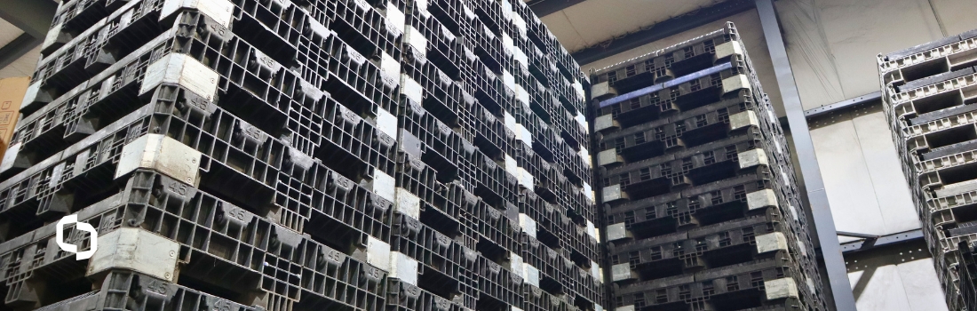 Stacked reusable plastic pallets in a warehouse, illustrating how tracking ESG requirements and criteria supports durable, low-waste supply chains.